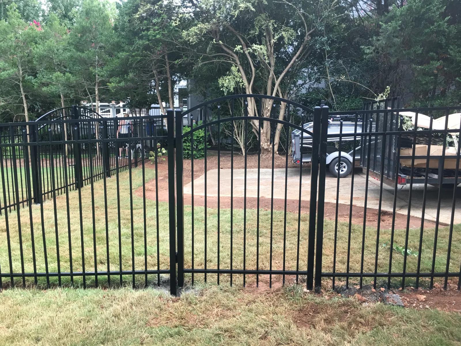 Black aluminum fence with an arched gate, installed by CC Fencing
