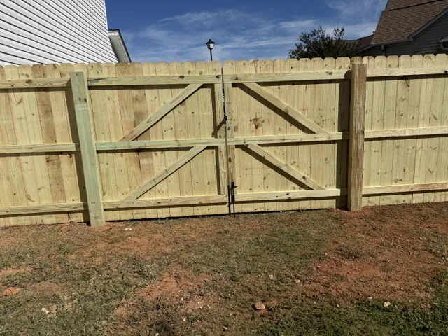 Wood privacy fence with a wide double drive gate