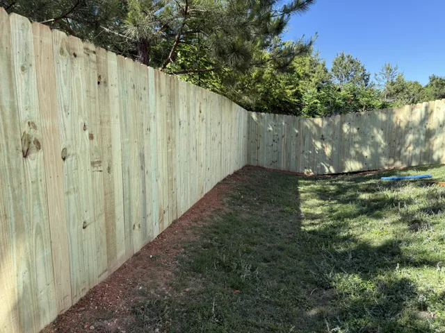 Full-height wood privacy fence running along a property line